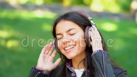 快乐混血少女听耳机音乐西班牙裔时髦女孩随节奏跳舞唱歌视频的预览图