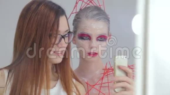 化妆师和她的客户用创造性的不同寻常的化妆自拍视频的预览图