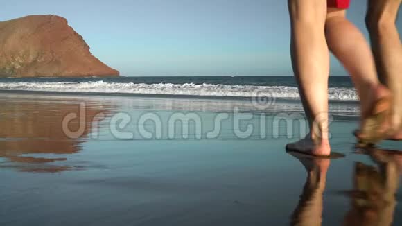 恋爱中的夫妻无忧无虑地走到海滩上的水里西班牙加那利群岛特内里费海岸图片视频的预览图