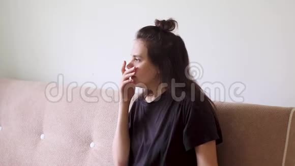 生病的年轻女子坐在家里喉咙痛咳嗽视频的预览图