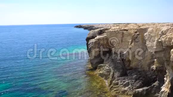 在阳光明媚的白天在壮观的海景中海浪在岩石上破碎晴天的海岩视频的预览图