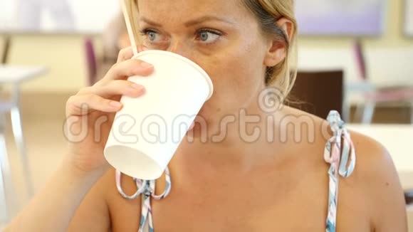 一个女人正在快餐店喝咖啡一次性杯子4K咖啡慢动作视频的预览图