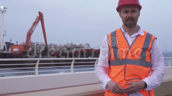 戴着头盔的人建筑师工程师经理用石头储备讲述海岸线的维修过程视频的预览图