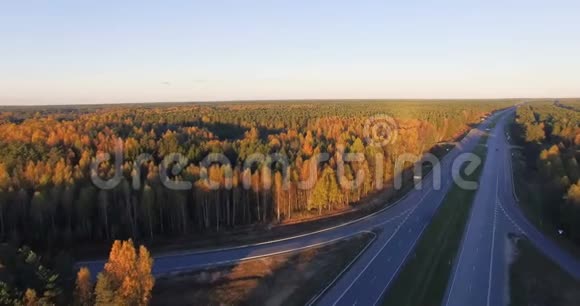 日落时沿着混合硬木和针叶林的交通高速公路的空中全景视频的预览图