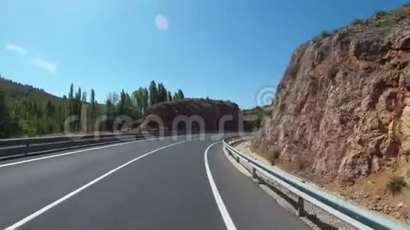摩托车手在西班牙的风景山沙漠风景和空山路上骑车第一人称观点视频的预览图