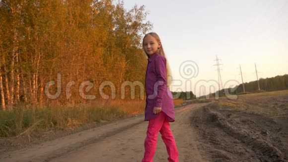 年轻的白种人女孩在乡间公路上跳跃白色金发长发女孩在户外跳跃视频的预览图