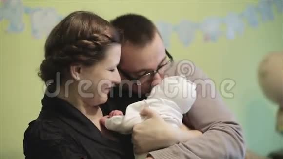 年轻的父母手牵手着一个新生儿视频的预览图