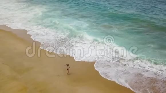 海滩比基尼女郎无忧无虑地把她的手臂伸向海滩的两边葡萄牙美丽的海洋海岸视频的预览图