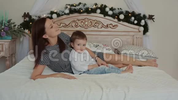 一位年轻的母亲和她的儿子躺在床上视频的预览图