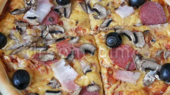 手拿一块意大利大比萨饼里面有黑橄榄培根腊肠和奶酪视频的预览图