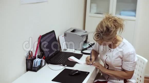 女医生坐在桌边写心电图结果视频的预览图