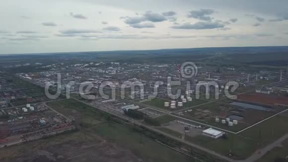 从城市外围的大工业区上方看背景是田野和树木多云视频的预览图