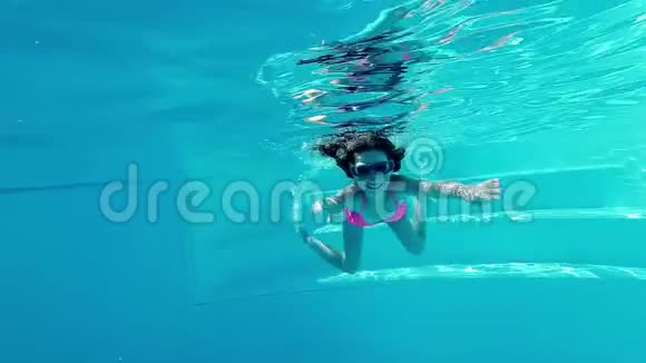 微笑的女孩在游泳池里水下游泳视频的预览图