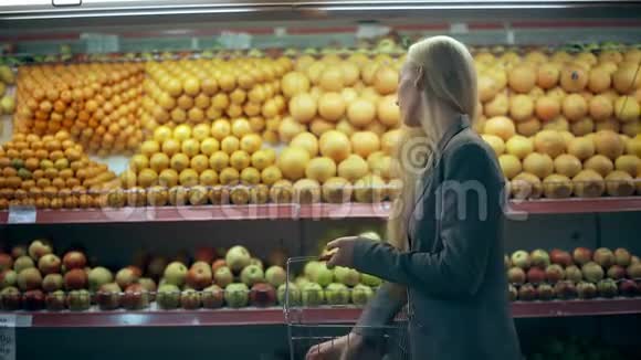 年轻女子在杂货店里选橘子视频的预览图