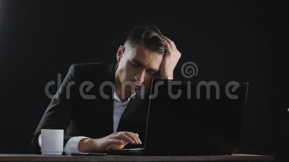 伤心疲惫的商人坐在办公桌旁视频的预览图