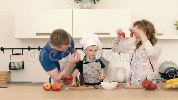 一个美丽的家庭正在家里的厨房准备一份美味的水果沙拉视频的预览图