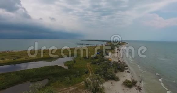 一个令人惊叹的空中景色白色灯塔和一座黑色边境塔在Dzharylhach岛上美丽的海岸被覆盖视频的预览图