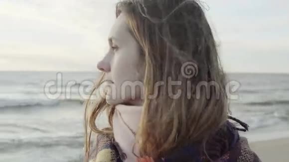 一幅年轻迷人的女画像站在海边用格子布望着远处思考着视频的预览图