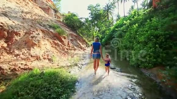 母亲的女儿走在阴凉的仙女溪边视频的预览图