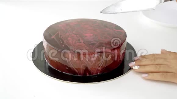 特写女性手切巧克力釉慕斯蛋糕视频的预览图