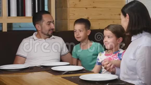 服务员给咖啡馆里的小女孩喝点饮料男人把一杯调味水放在桌子上视频的预览图