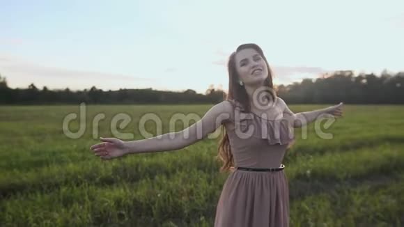 绿色田野里年轻快乐的女孩唱着这首歌视频的预览图