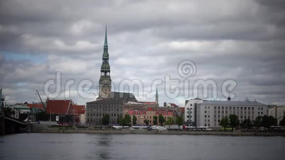 在多云的天空背景下透过圣彼得教堂的道加瓦河观看拉脱维亚里加视频的预览图