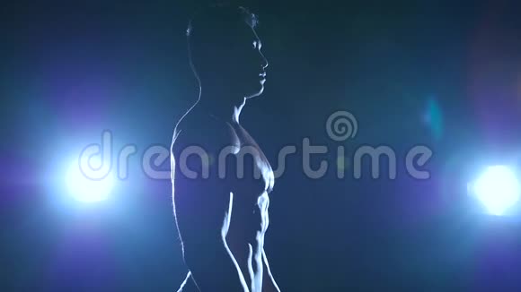 亚洲健美运动员展示了他的喋喋不休的肌肉黑色背景慢动作剪影视频的预览图