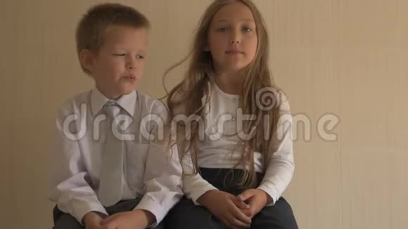 回学校去穿着校服的蓝眼睛和金发的快乐孩子的肖像男孩和学龄前女孩视频的预览图