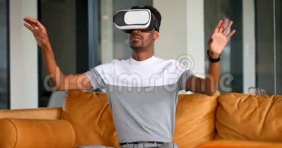 4k沙发上使用虚拟现实耳机的男性高管视频的预览图