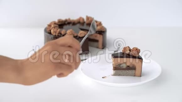 特写女性手切巧克力釉慕斯蛋糕视频的预览图