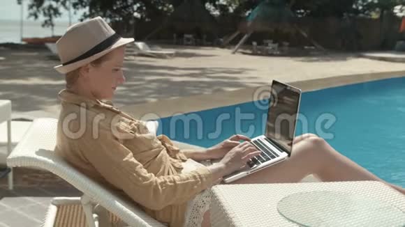 在豪华度假村用电脑工作的女人视频的预览图