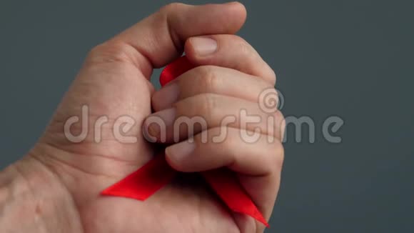 手拿红色意识丝带象征艾滋病病毒视频的预览图