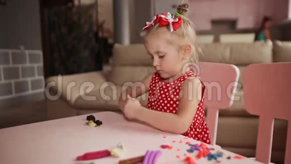 一个迷人的小女孩在她房间的一张桌子上用塑料雕刻而成视频的预览图