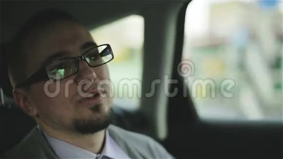 坐在出租车后座上的商人说话微笑视频的预览图