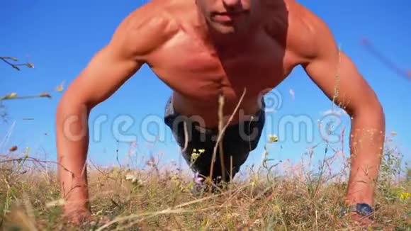 健身俯卧撑健身男子做俯卧撑外面的自然慢动作视频的预览图