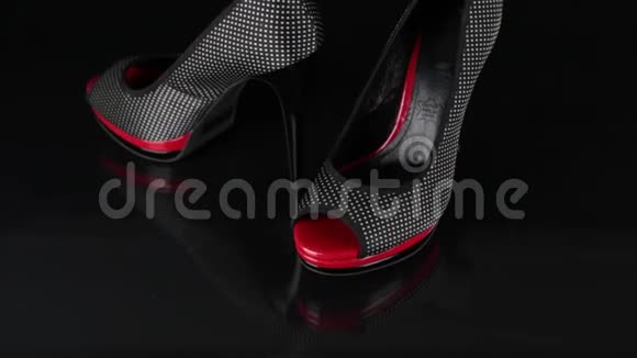 走近一双黑色的鞋子站在黑色的背景上时尚背景视频的预览图