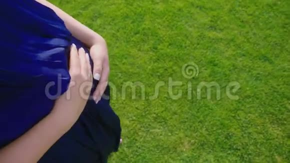 一位孕妇赤脚走在草地上把他的手放在肚子上POV视频视频的预览图