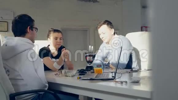 创意工程师团队测试创新的机器人技术仿生手臂在一个明亮的现代办公室视频的预览图