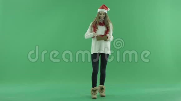 戴着圣诞帽的漂亮年轻女人打开了空的圣诞礼物变得悲伤背景上的颜色钥匙视频的预览图