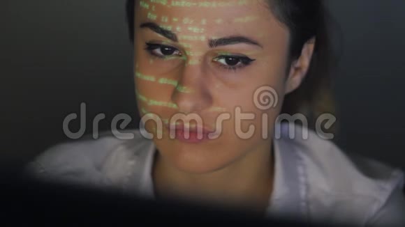 年轻女性擦洗槽电脑代码双码投影女性面部视频的预览图