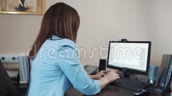 女商人黑发女人坐在办公室在电脑键盘上打字视频的预览图