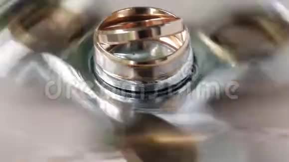 新娘和新郎的结婚戒指在旋转器上旋转特写镜头视频的预览图