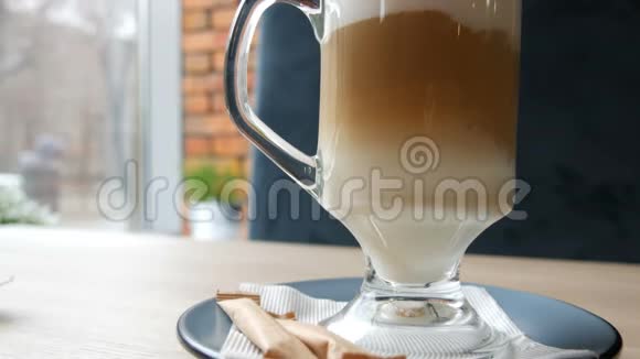 咖啡拿铁与勺子混合将咖啡与牛奶混合近距离观看视频的预览图