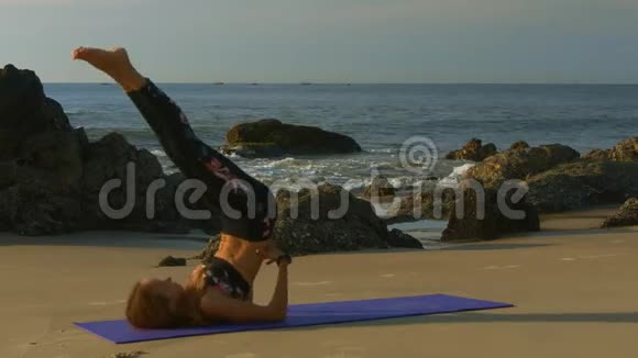 金发女郎在沙滩上练习瑜伽对抗海浪视频的预览图