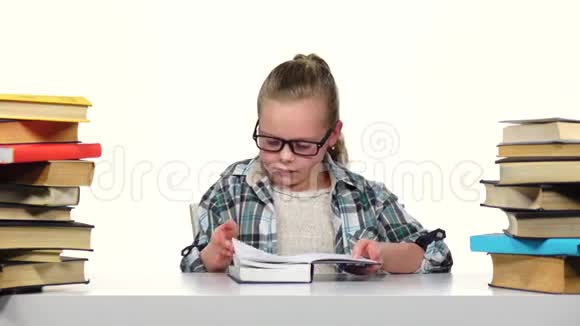 女孩选择了一本书并开始阅读它白色背景视频的预览图