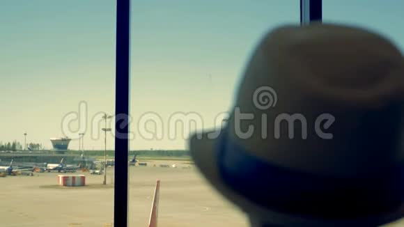 机场里的一个孩子一个男孩透过窗户看机场跑道视频的预览图