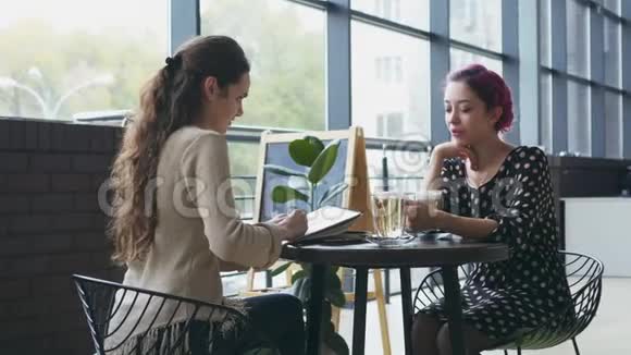 女人在咖啡馆画素描和朋友聊天视频的预览图