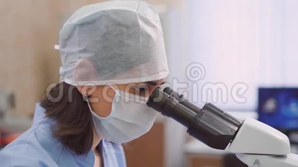 近距离拍摄一名妇女的脸她通过显微镜检查病人实验室检查视频的预览图