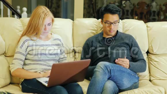 有笔记本电脑的白人女人一个有电子书的亚洲人一起度过时光视频的预览图